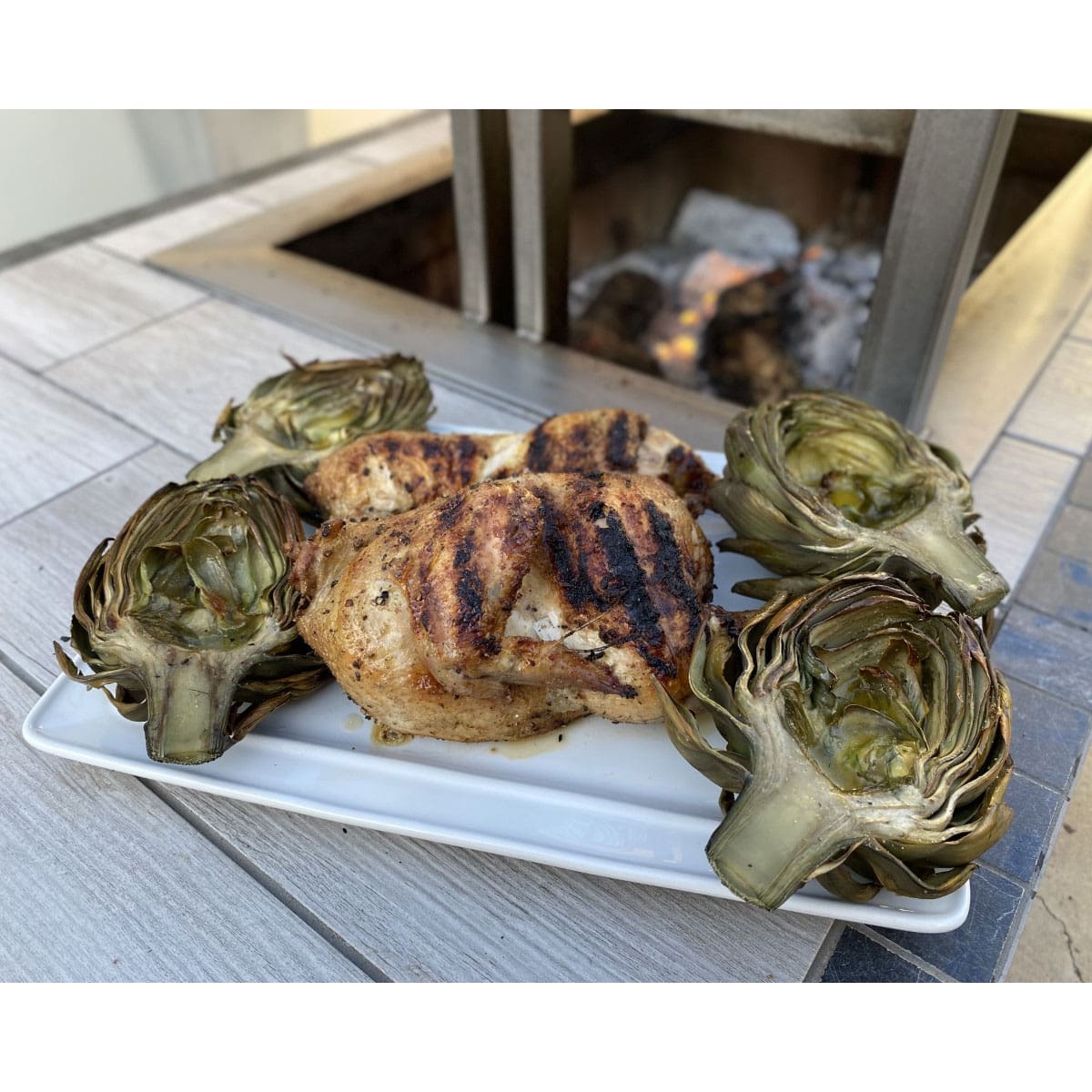 Grilled artichoke and chicken with sear marks from an Argentinian grill grate